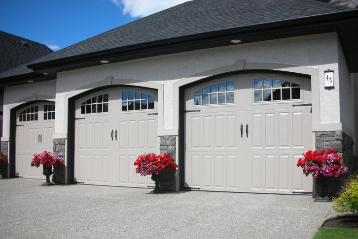 Elegant garage with two doors, adorned by vibrant flowerpots, showcasing modern home exterior design.