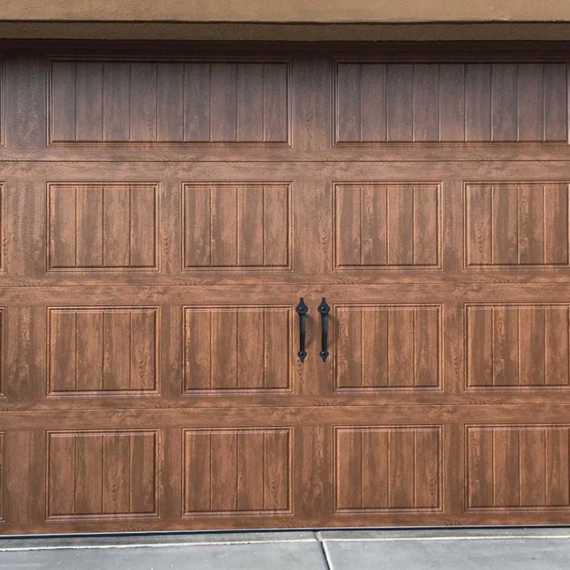 Elegant wooden garage door with decorative black handles and panel design, enhancing curb appeal for homes.