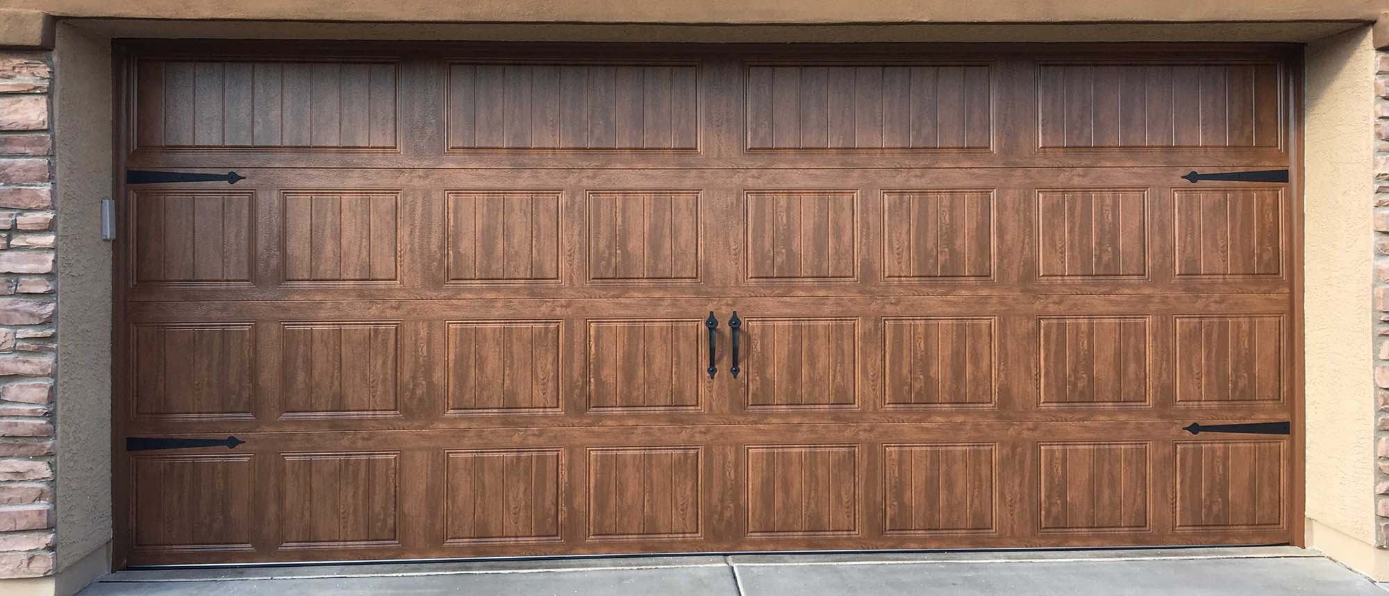 Elegant wooden garage door with decorative black handles and panel design, enhancing curb appeal for homes.